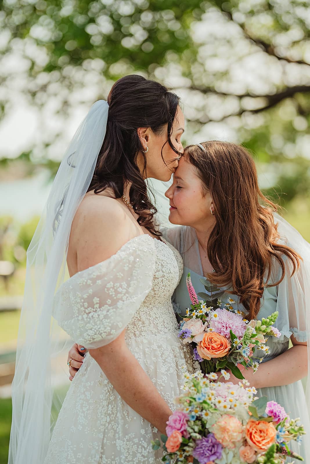 Brudepar foran bil med blomsteroppsats i bakgrunnen