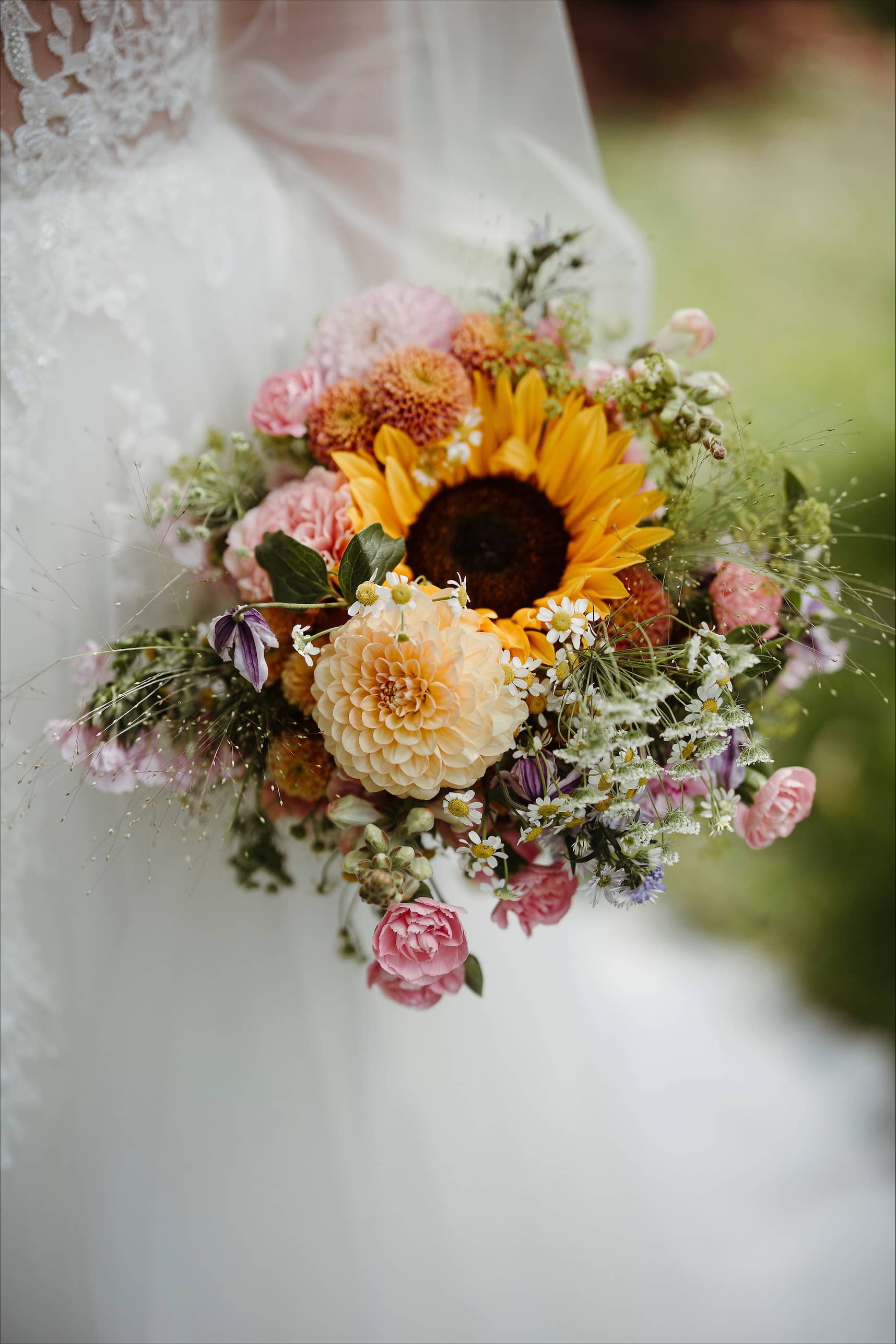 Brudepar foran bil med blomsteroppsats i bakgrunnen